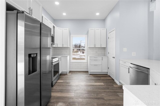 kitchen featuring tasteful backsplash, appliances with stainless steel finishes, dark hardwood / wood-style floors, and white cabinets