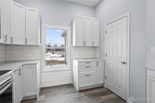 kitchen featuring white cabinetry, backsplash, dark hardwood / wood-style flooring, and electric range