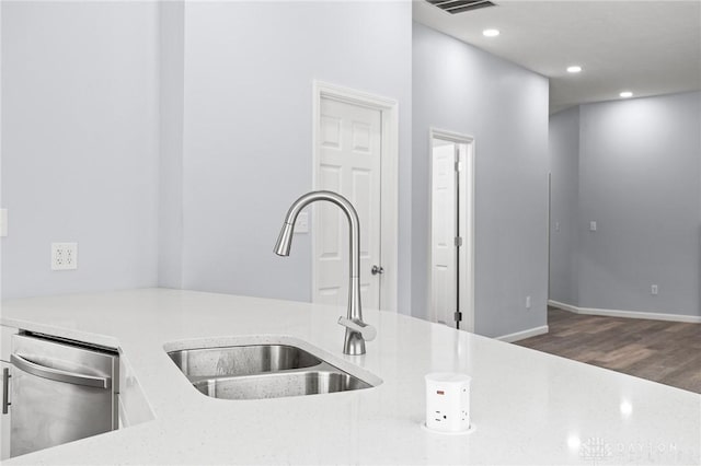 kitchen featuring sink, light stone countertops, dark hardwood / wood-style floors, and dishwasher