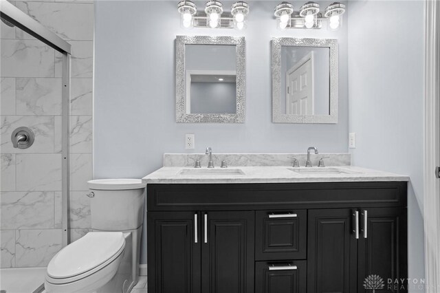 bathroom featuring vanity, toilet, and a tile shower