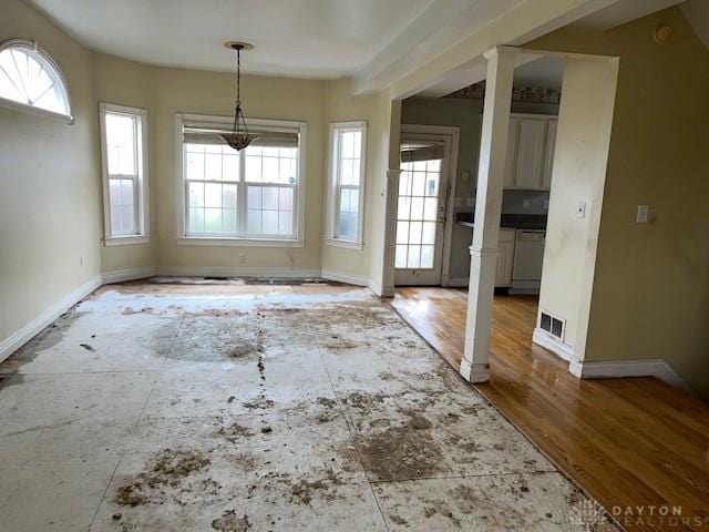 unfurnished dining area with wood-type flooring, decorative columns, and plenty of natural light