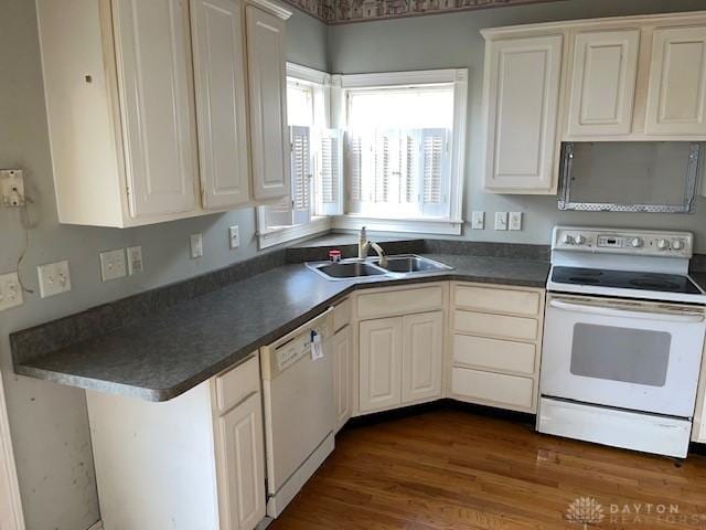 kitchen featuring white cabinetry, sink, white appliances, and dark hardwood / wood-style floors