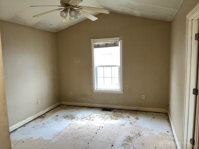 empty room with ceiling fan and lofted ceiling