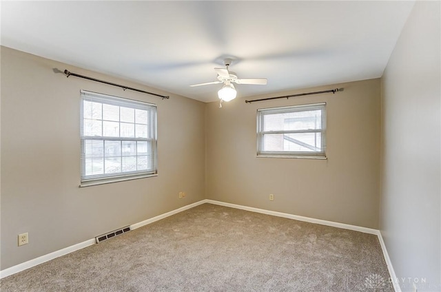 empty room with ceiling fan, a healthy amount of sunlight, and carpet