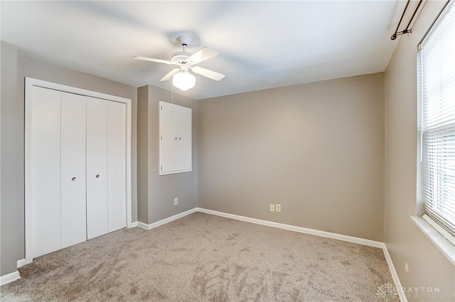 unfurnished bedroom featuring light colored carpet, ceiling fan, and a closet