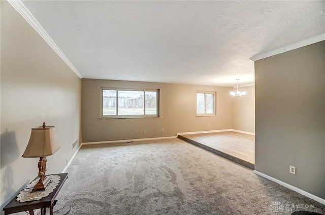 carpeted spare room with an inviting chandelier and crown molding