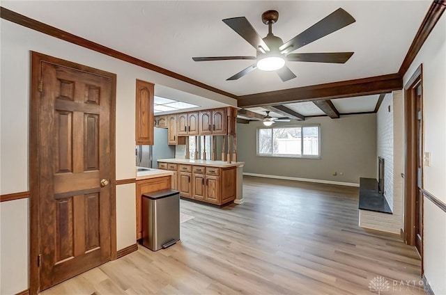 kitchen with stainless steel refrigerator, ceiling fan, crown molding, beam ceiling, and light hardwood / wood-style flooring