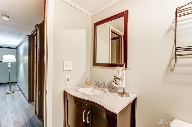 bathroom featuring ornamental molding, hardwood / wood-style floors, and vanity