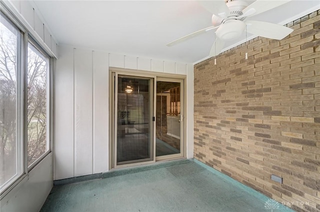 unfurnished sunroom with ceiling fan