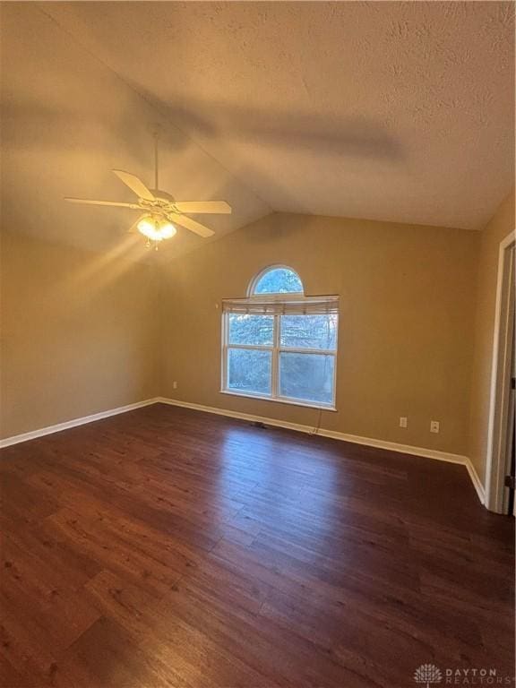 unfurnished room featuring ceiling fan, dark wood-type flooring, a textured ceiling, and vaulted ceiling