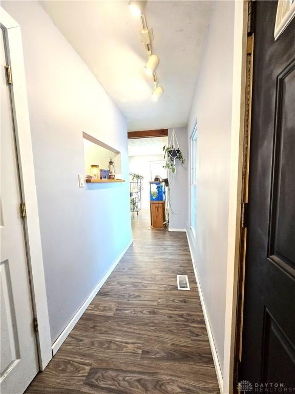 hall with rail lighting and dark hardwood / wood-style floors