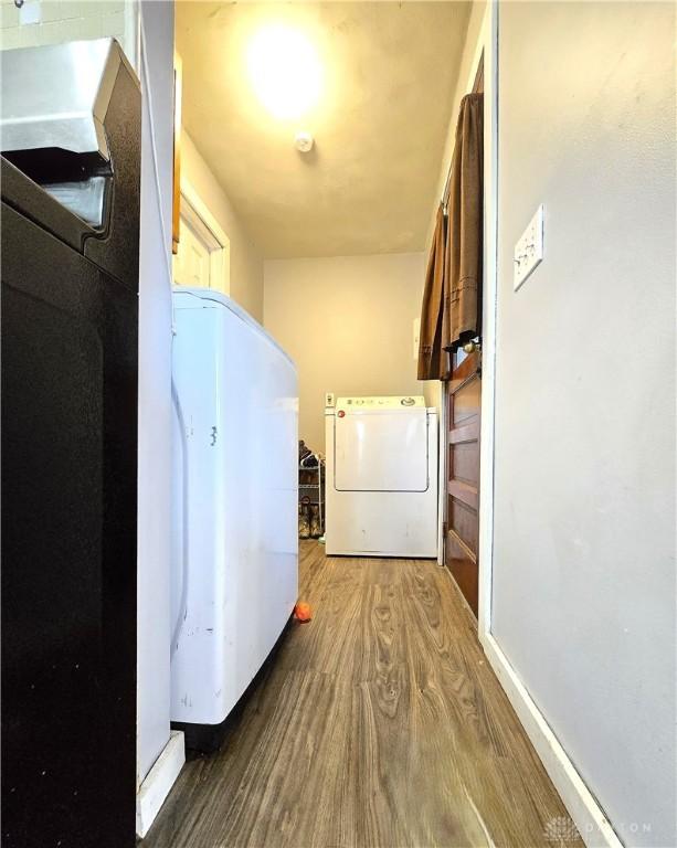 laundry room with wood-type flooring and washer and dryer