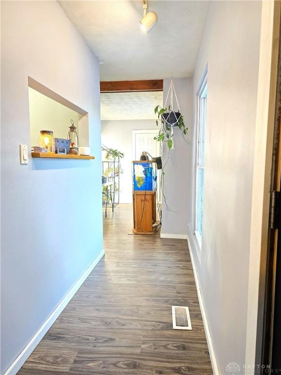 hall with dark wood-type flooring and beam ceiling