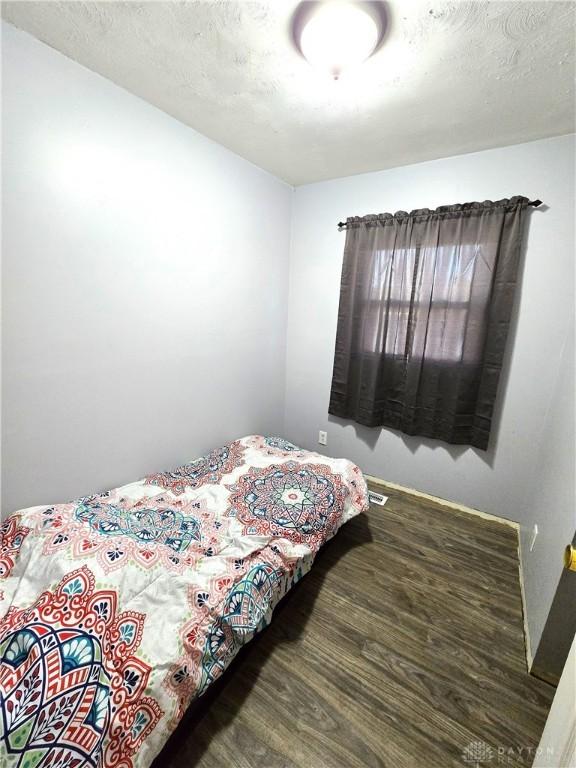 bedroom featuring dark wood-type flooring and a textured ceiling