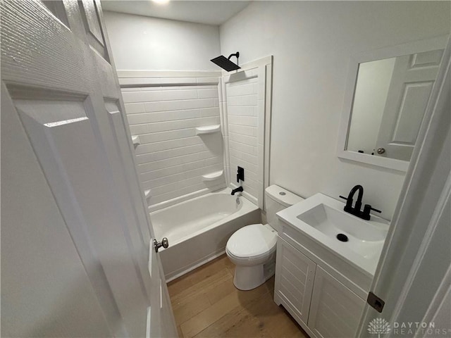 full bathroom with wood-type flooring, vanity, washtub / shower combination, and toilet