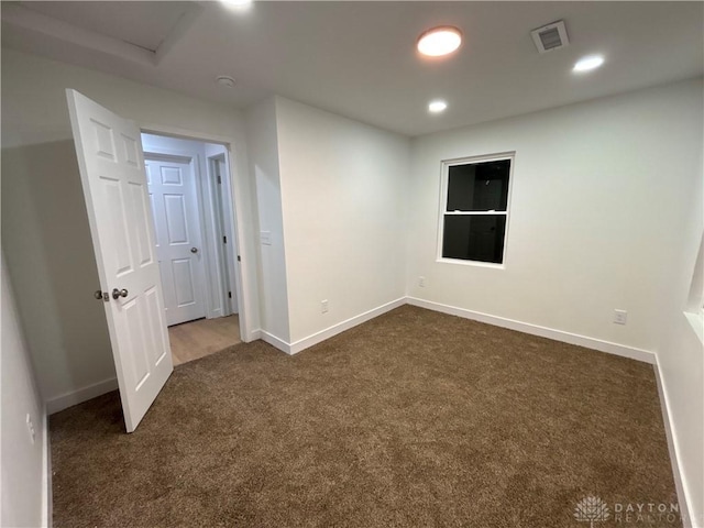 empty room featuring dark carpet