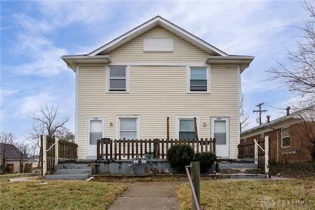 rear view of house featuring a lawn