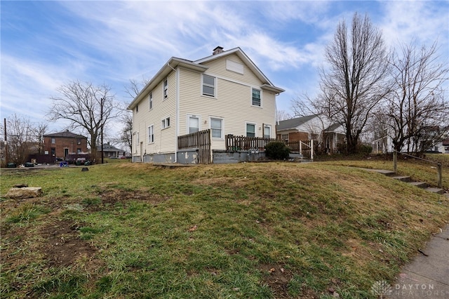 view of property exterior featuring a wooden deck and a lawn