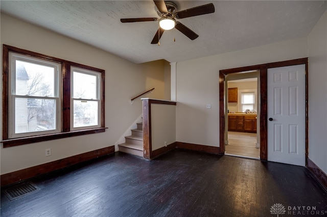 spare room with ceiling fan, dark wood-type flooring, and a textured ceiling