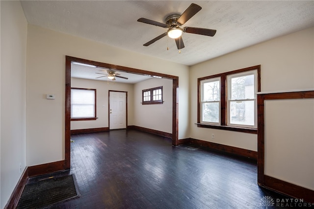 unfurnished room featuring ceiling fan, dark wood-type flooring, and a textured ceiling