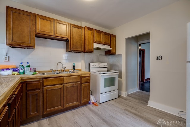 kitchen with electric stove, light hardwood / wood-style floors, sink, and decorative backsplash