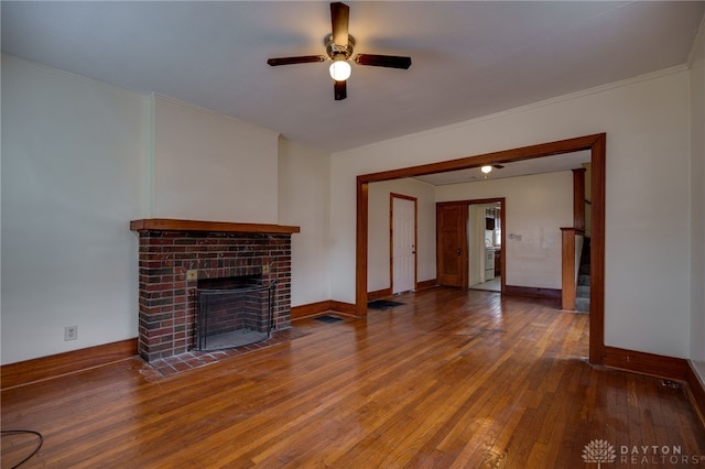 unfurnished living room featuring hardwood / wood-style floors, a fireplace, ornamental molding, and ceiling fan