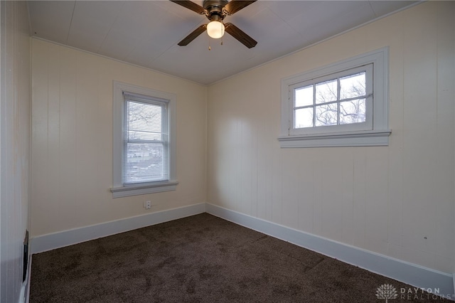 unfurnished room featuring plenty of natural light, ceiling fan, and dark colored carpet