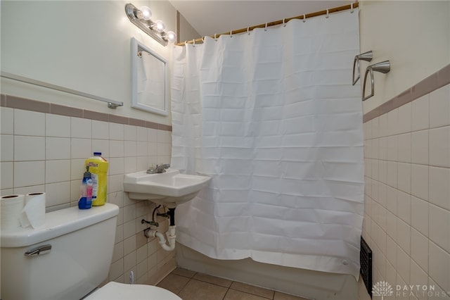 bathroom featuring tile patterned flooring, toilet, and tile walls