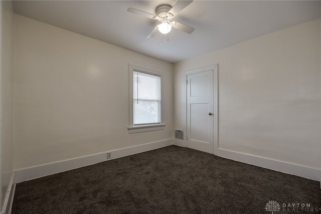 unfurnished room featuring ceiling fan and dark colored carpet