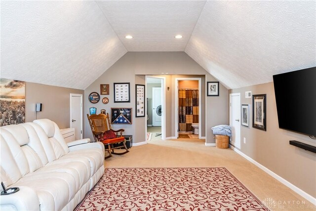 carpeted living room featuring vaulted ceiling and a textured ceiling