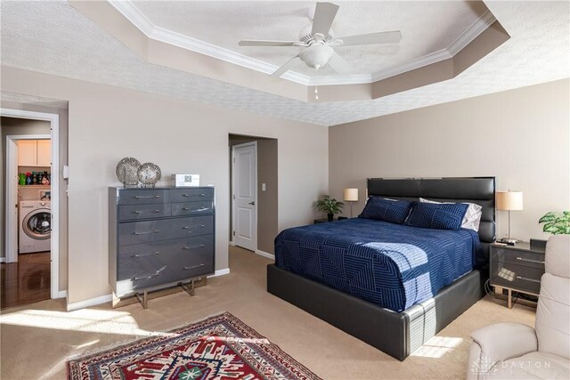 carpeted bedroom featuring washer / clothes dryer, crown molding, a raised ceiling, and a textured ceiling