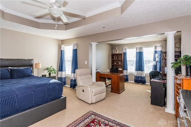 carpeted bedroom with crown molding, a tray ceiling, decorative columns, and a textured ceiling