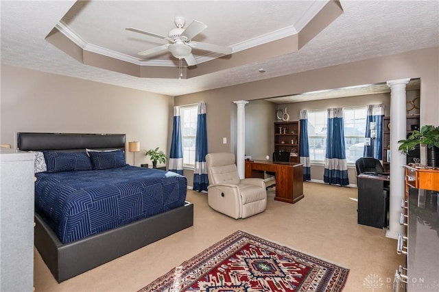 carpeted bedroom with crown molding, a tray ceiling, a textured ceiling, and ornate columns