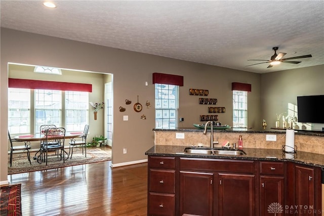 kitchen with dark stone countertops, sink, and plenty of natural light