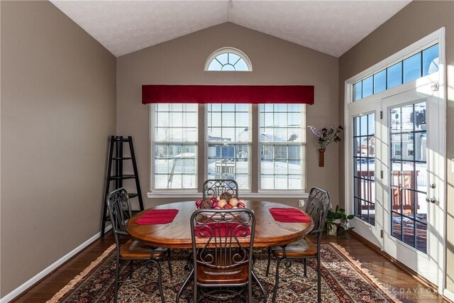 dining area with wood-type flooring and lofted ceiling