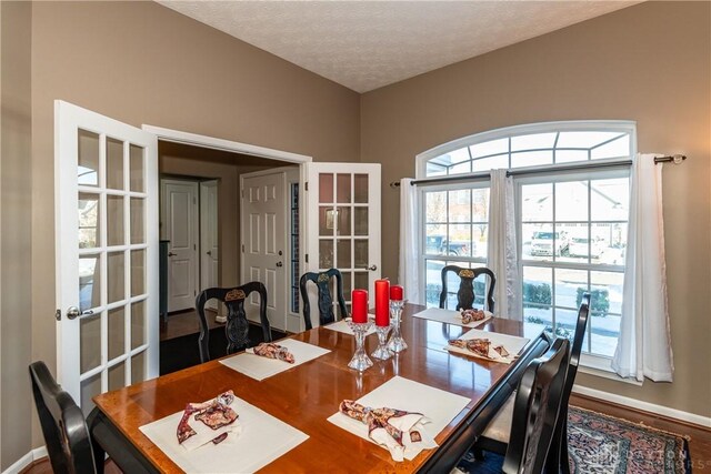 dining space with a textured ceiling and french doors