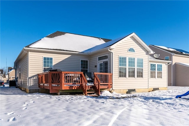 snow covered back of property featuring a wooden deck