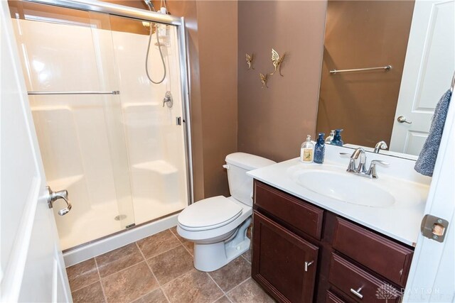 bathroom featuring vanity, toilet, and a shower with shower door