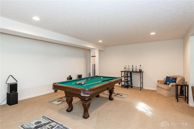 game room with billiards, light colored carpet, and a textured ceiling