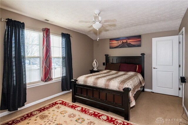 carpeted bedroom with ceiling fan and a textured ceiling