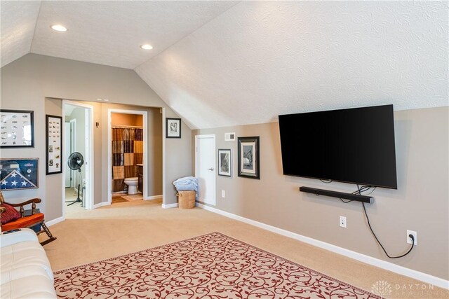 carpeted living room featuring vaulted ceiling and a textured ceiling