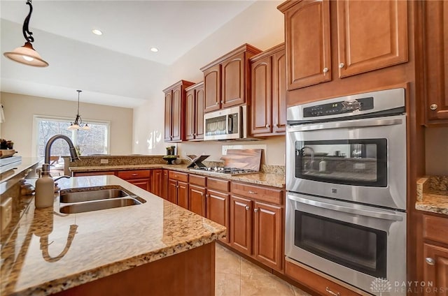 kitchen with appliances with stainless steel finishes, decorative light fixtures, sink, light tile patterned floors, and light stone countertops