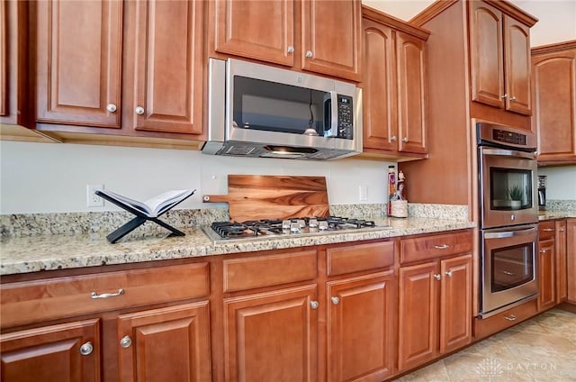 kitchen featuring appliances with stainless steel finishes and light stone countertops