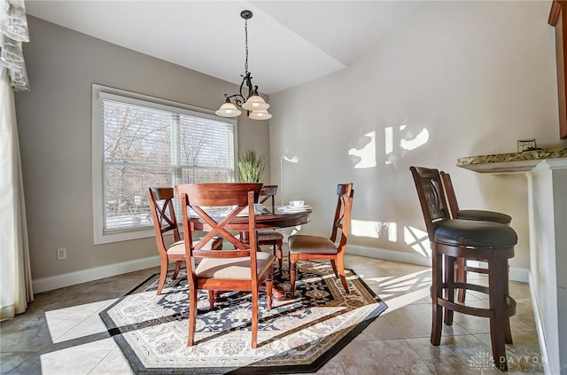 dining space with light tile patterned floors and vaulted ceiling