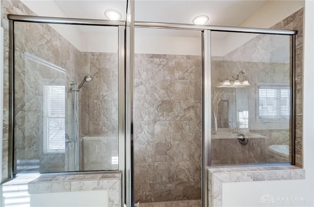 bathroom featuring a healthy amount of sunlight and a shower with shower door