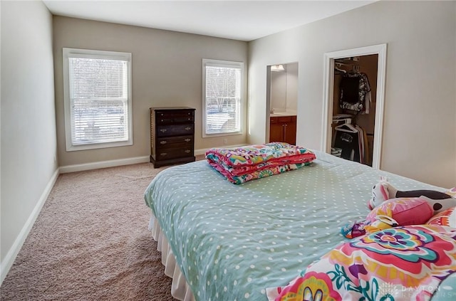 bedroom featuring ensuite bath and light carpet