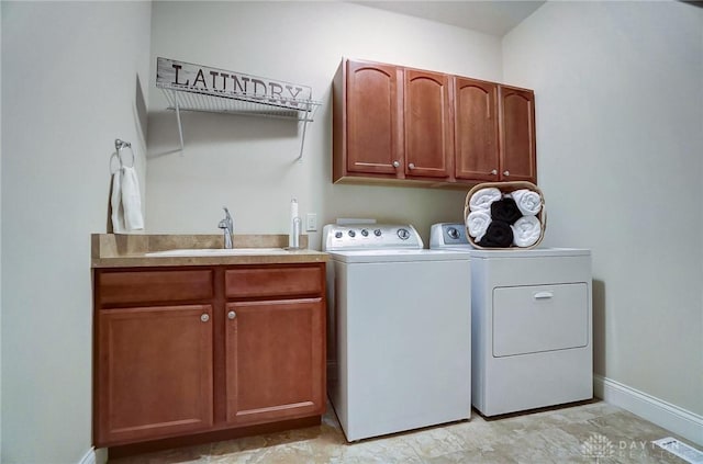 washroom featuring cabinets, sink, and independent washer and dryer