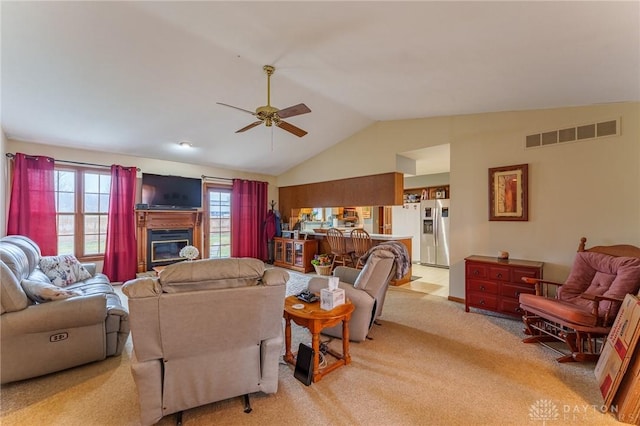 carpeted living room featuring ceiling fan and lofted ceiling