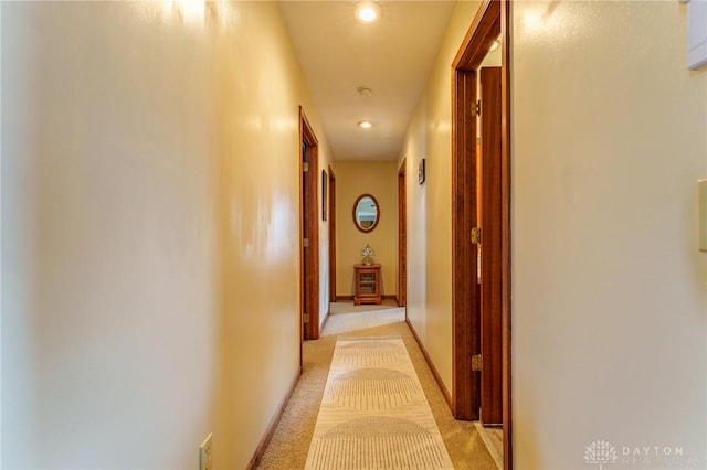 hallway featuring light colored carpet