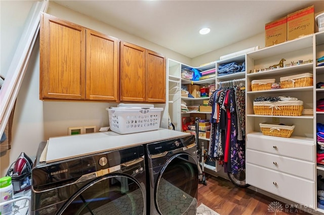 washroom featuring separate washer and dryer, dark hardwood / wood-style flooring, and cabinets